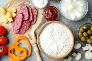 Concept of cooking pizza on gray textured background, top view