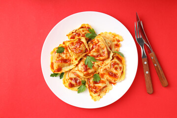 Delicious food concept with ravioli on red background