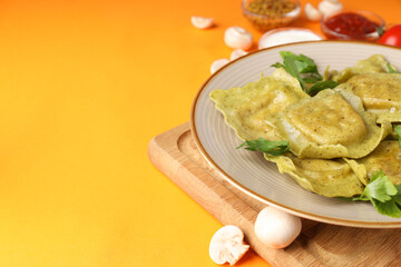 Delicious food concept with ravioli on orange background