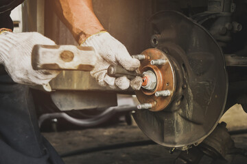 The mechanics remove the car wheel hub in the auto repair shop