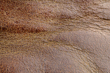Macro background made of seamless wavy brown natural leather.