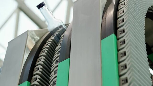 The movement of empty glass bottles on a conveyor belt.