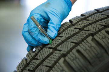 Tyre being checked for tread depth