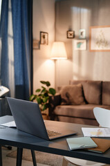 Close-up of laptop and documents on the table in the room at home