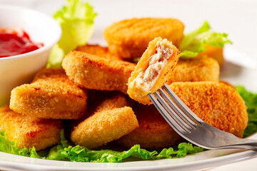 Fried chicken breast nuggets, on lettuce leaves, with tomato sauce, horizontal, no people, selective focus,