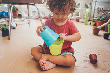 Cute baby caring the plants in home