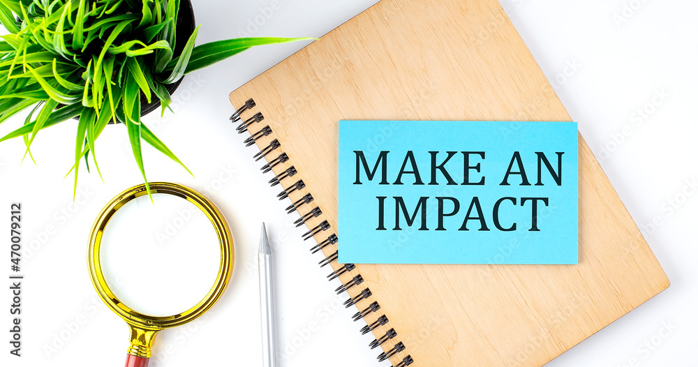 Poster notebook with tools and notes with text on the blue sticker ake an impact
