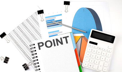 Obraz premium Text POINT on a notebook on the diagram and charts with calculator and pen