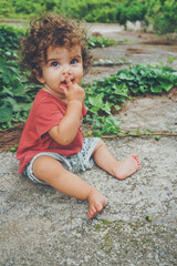 Cute toddler sit on the backyard floor