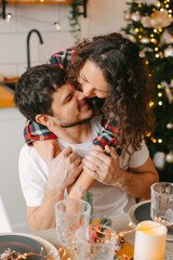 Young couple in a house in a romantic winter landscape in a christmas interior.