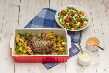 Red oven dish with raosted pork meat and potatoes