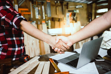 corporation and successful working handshake after success deal and teamwork of carpenter and...