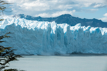 Small ice chunks from the edge of Perito Moreno Glacier are falling and calving into the lake