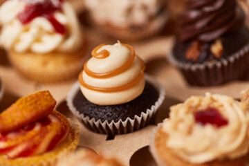 Obraz na płótnie Canvas Cupcake with caramel cream between many cupcakes