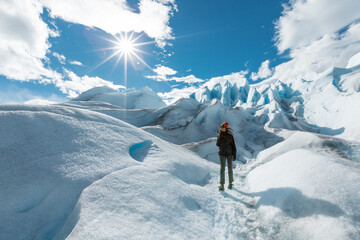 A woman stands on the ice formation of the Perito Moreno Glacier and smiling