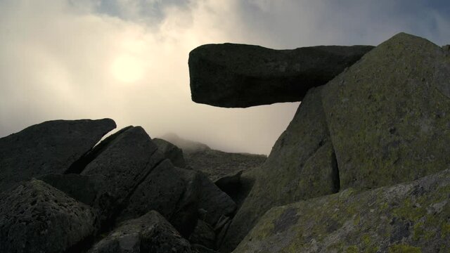 The cantilever stone in Snowdonia with sun and low cloud background