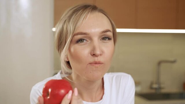 The girl is biting a red apple. Bite fresh apple with happiness to diet, weight and calories control and good health lifestyle concept. Healthy teeth