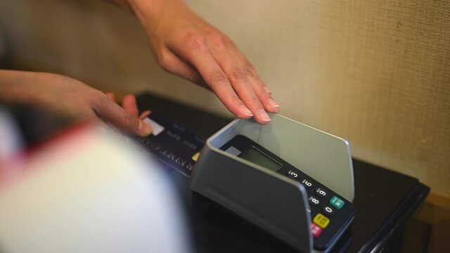 クレジットカードでの会計をする女性の手元