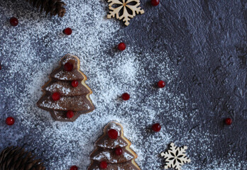 Christmas muffin in the form of a fir tree with berries, powdered sugar on a dark background