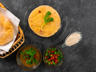 Homemade corn flatbread cilantro greens tomato salsa. Handmade mexican Tortilla Taco Quesadilla vegetable. Traditional Indian Makki ki roti bread top view. Gluten free flour dough authentic cuisine.