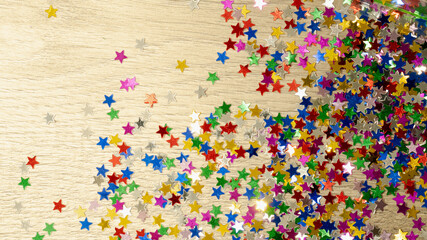 background of colored stars, colored confetti, plastic stars scattered on the floor