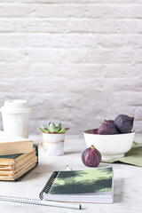 Creative workplace with a bowl of figs, side view. 