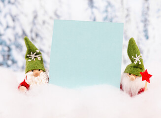 Little cute christmas gnome standing in the snow, forest, festive greeting card, copy space