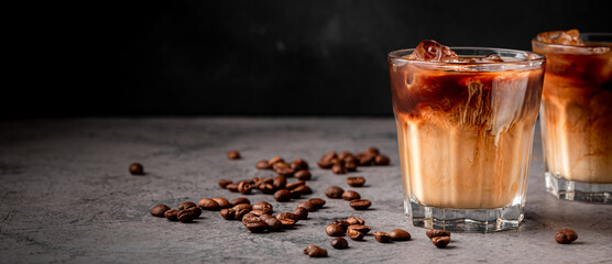 Ice coffee in a glass with cream poured over.