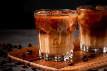Ice coffee in a glass with cream poured over.