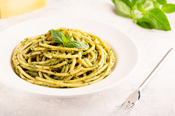 Pasta spaghetti with pesto sauce and fresh basil leaves