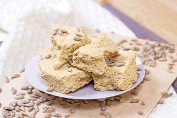 Traditional sweet turkish delight halva pieces with sunflower seeds on light background.