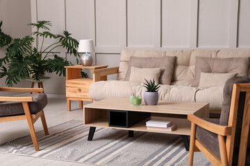 Stylish living room interior with comfortable sofa, armchairs and beautiful plants