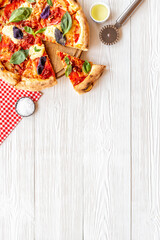 Sliced italian pizza margherita with tomatoes cheese and basil, top view