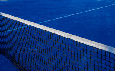 Partial view of a blue paddle tennis court