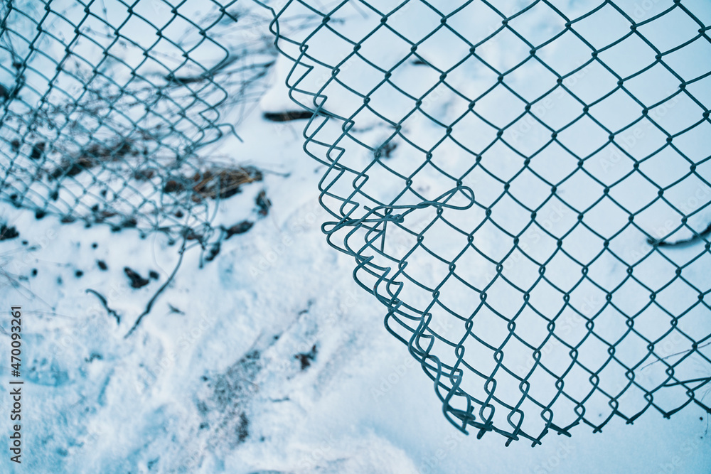 Wall mural Escape from prison or closed institution for mentally ill. Hole in wire border fence. Winter snowy weather. Unauthorized entry is prohibited. Maximum security detention facility. Illegal trespassing.