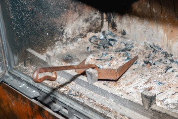 Fireplace cleaning. Fireplace cleaning tools. A shovel with ash in a burnt-out fireplace. Daily winter routine