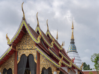 Fototapeta premium Scenic landscape view of ancient Wat Pan Ping vihara and white stupa after reconstruction following fire, Chiang Mai, Thailand