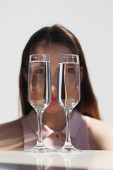 Conceptual surreal portrait Caucasian woman looking through two glasses of water