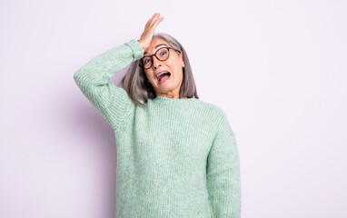 senior pretty woman raising palm to forehead thinking oops, after making a stupid mistake or...