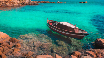 little old boat anchored in a turquoise sea La Maddalena Sardinia