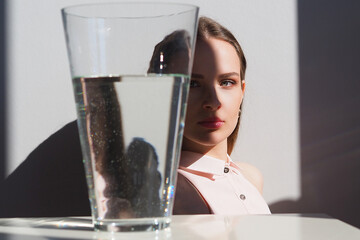 Conceptual surreal portrait Caucasian woman looking through a vase of water