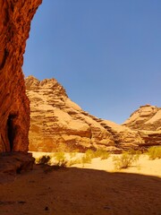 Dans la zone protégée du désert de Wadi Rum en Jordanie, avec de hautes montagnes rocheuses, exploration dans l'inconnu, sous un soleil et forte chaleur, tas de rochers ou débris, dans l'ombre
