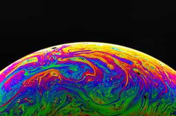 Virtual reality space with abstract multicolor psychedelic planet. Closeup Soap bubble like an alien planet on black background.