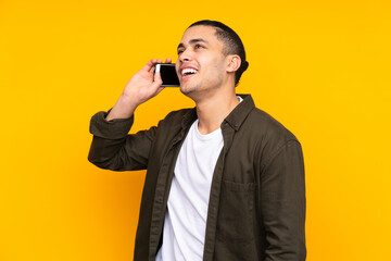 Naklejka premium Asian handsome man isolated on yellow background smiling and showing victory sign