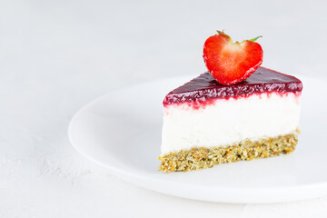 A piece of raw mousse cake with strawberries on a light background. Sugar, gluten, lactose free, vegan. Horizontal orientation, copy space.