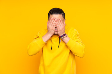 Asian handsome man isolated on yellow background in back position and thinking