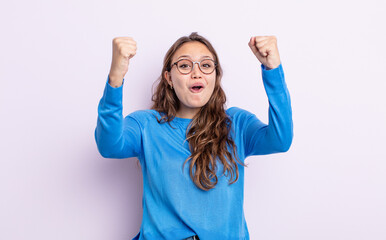 hispanic pretty woman celebrating an unbelievable success like a winner, looking excited and happy...