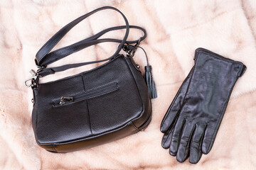 stylish leather gloves and bag on fur background, fashion