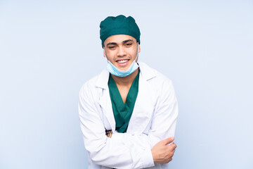 Surgeon man with uniform isolated on blue background laughing