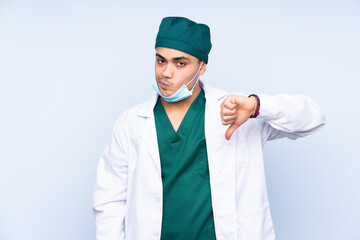 Surgeon man with uniform isolated on blue background showing thumb down sign